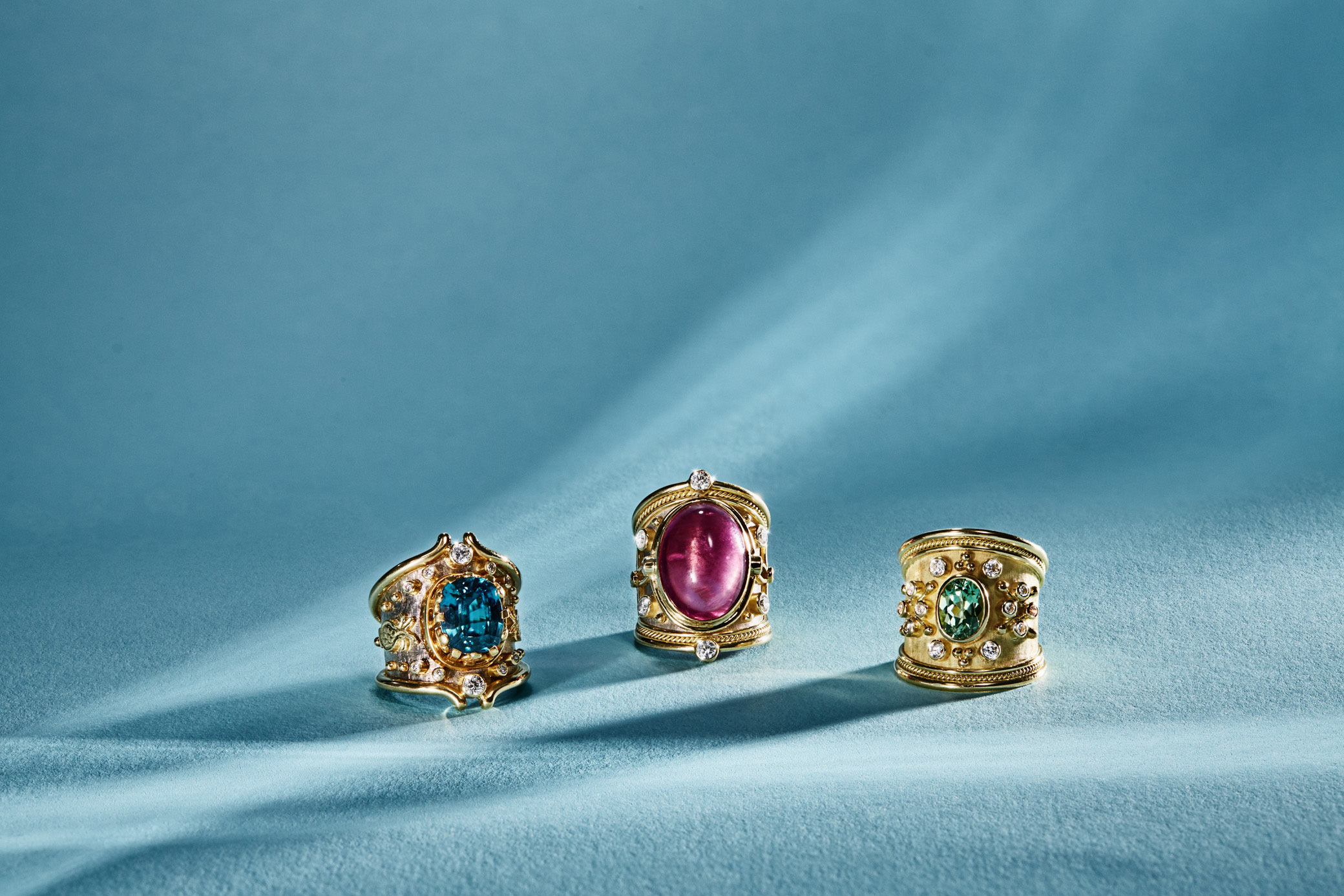 Jewellery photography - 3 templar rings on blue background with shafts of light.  Image shot in London studio for jewellers 