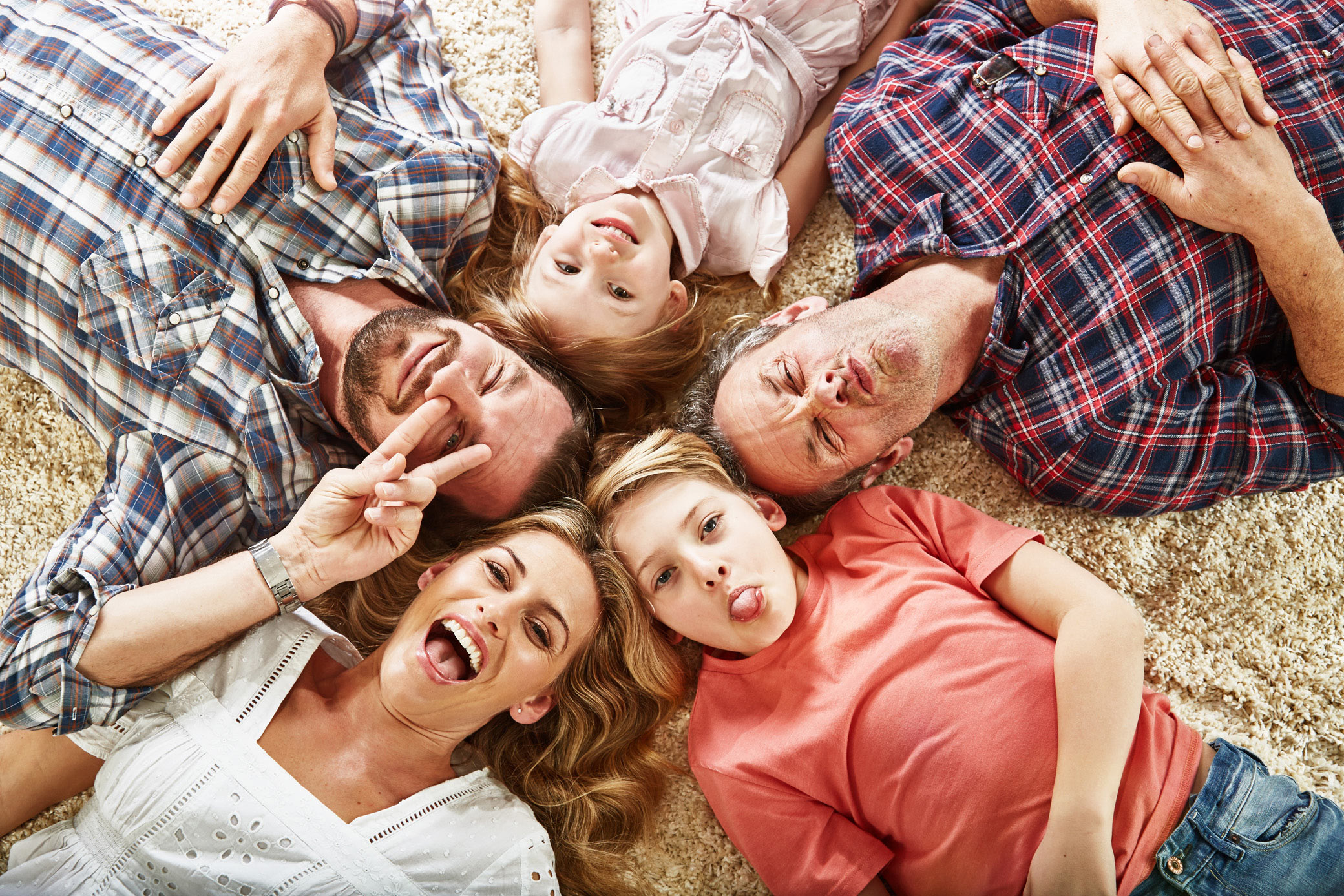 Lifestyle photographer - surrey, uk - family lying on ground smiling.  Photographed in the studio for Mobile phone company.  Images used in advertising and marketing.